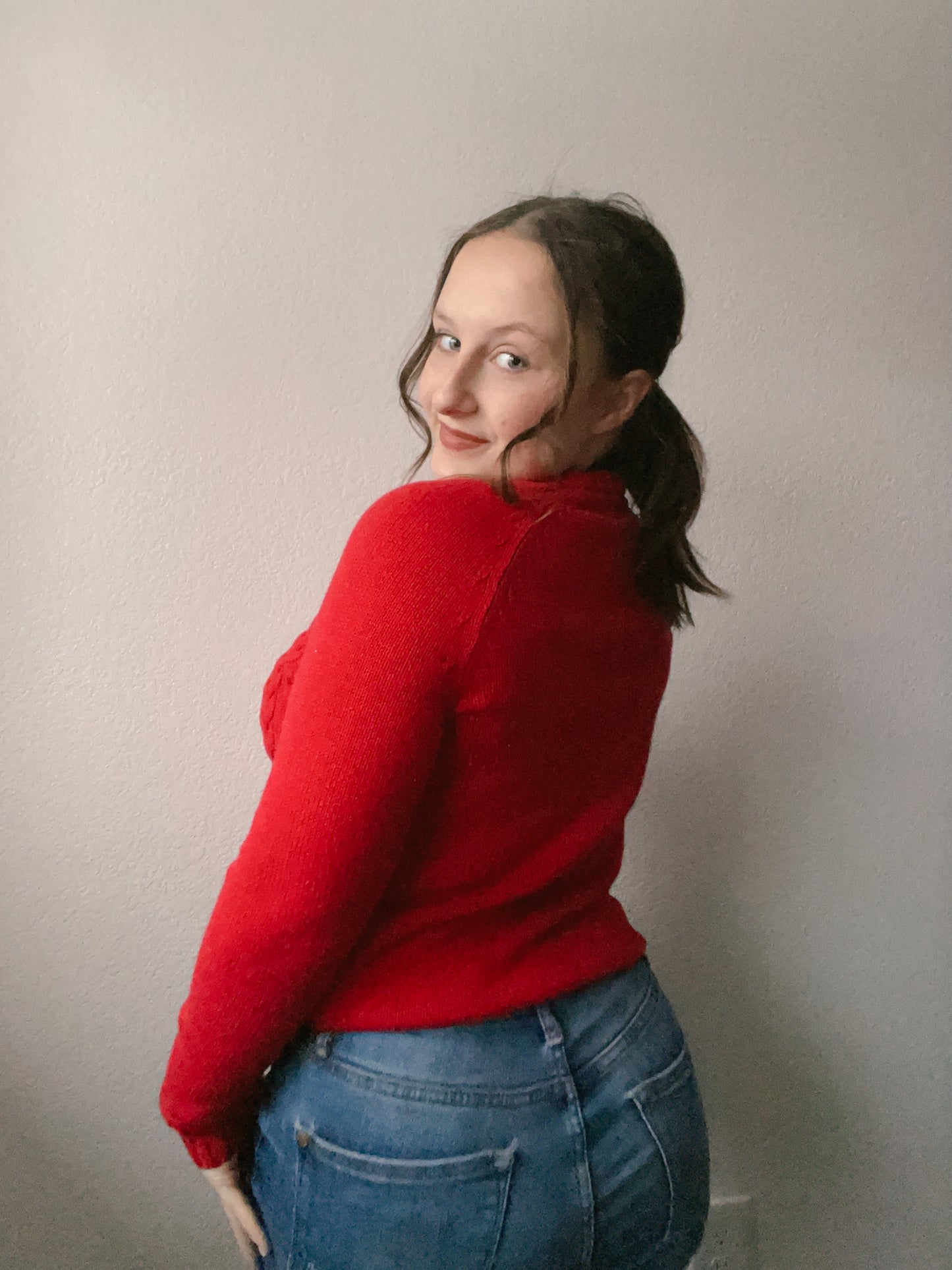 Person wearing a red cable knit sweater against a plain background Red Classic Cable Knit Sweater | From the Rack | Grace Thrifts