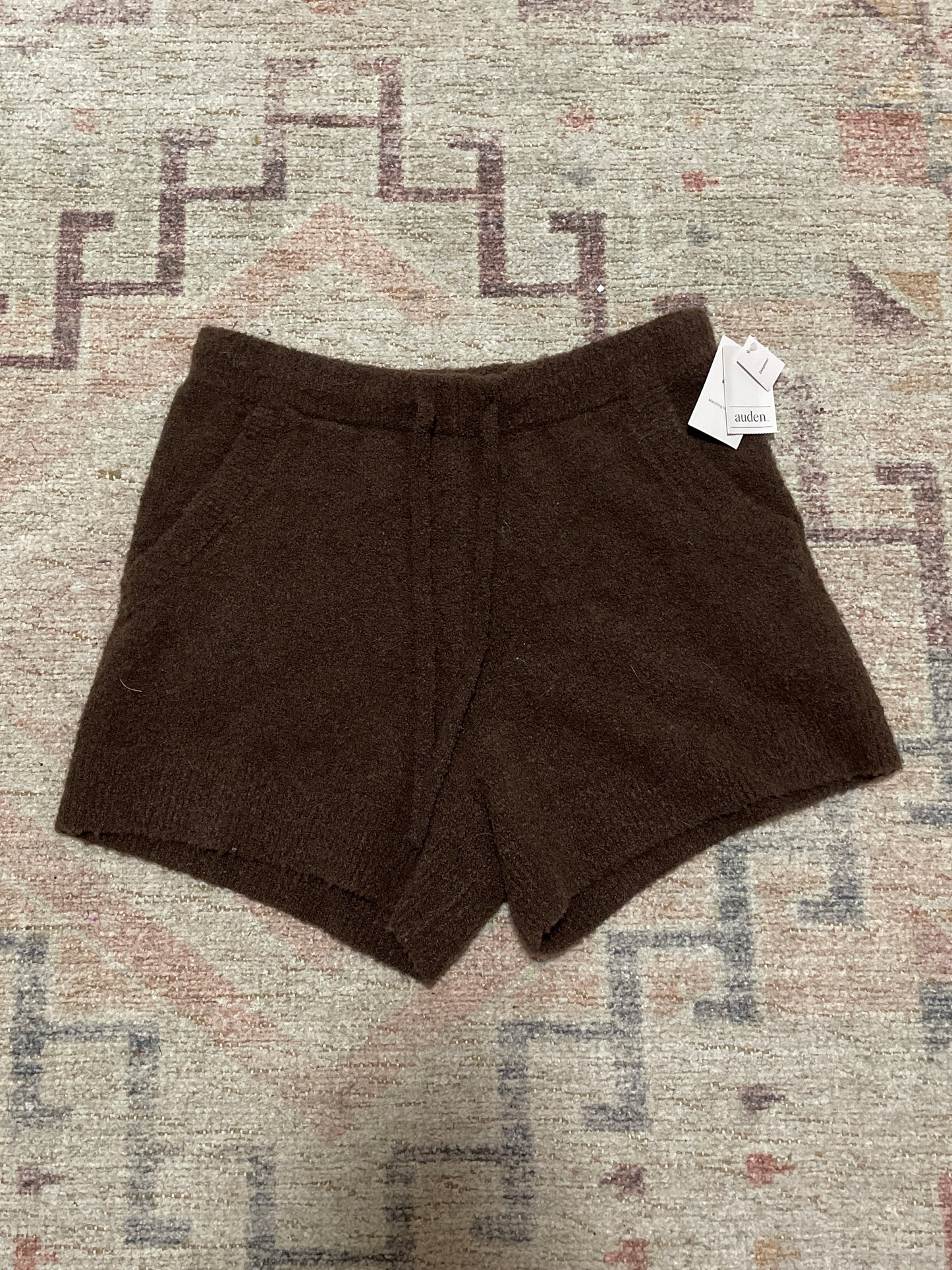 Brown shorts with a tag on a patterned rug NWT Brown Fuzzy Lounge Shorts | From the Rack | Grace Thrifts