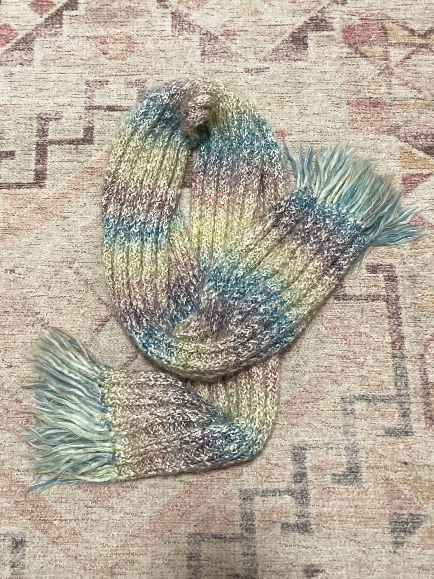 Multicolored scarf with tassels on a textured surface Knit Pastel Scarf | From the Rack | Grace Thrifts