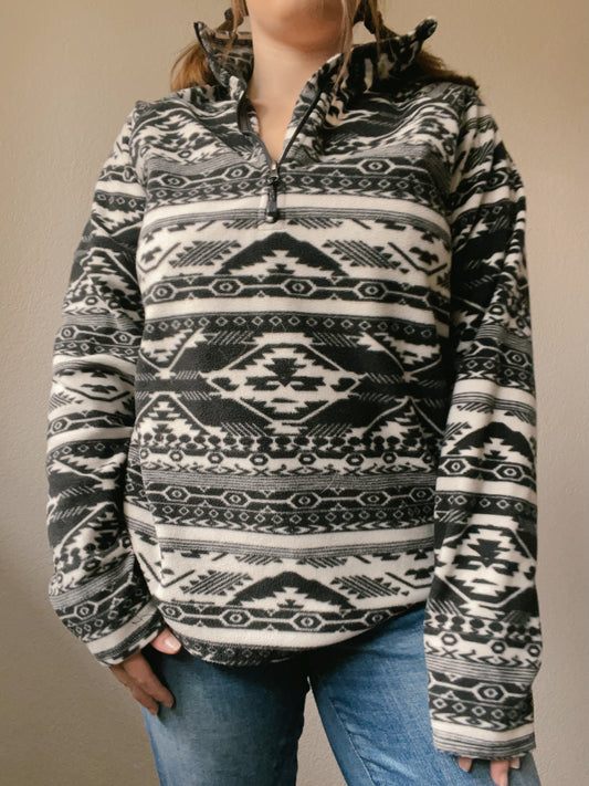 Person wearing a black and white patterned pullover against a plain background B&W Eddie Bauer Pullover | From the Rack | Grace Thrifts
