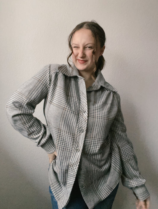 Woman wearing a checkered jacket against a plain background Grey Houndstooth Lightweight Jacket | From the Rack | Grace Thrifts
