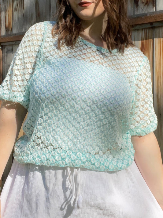 Woman wearing a light blue and white patterned top outdoors against a wooden fence | Grace Thrifts