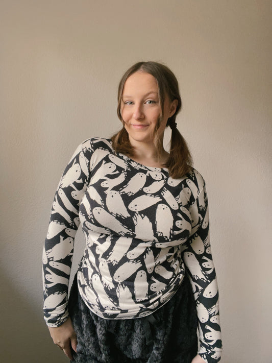 Person wearing a black and white patterned sweater against a plain background