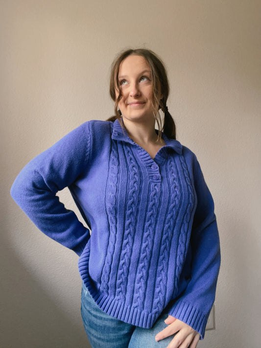 Woman wearing a blue cable knit sweater against a plain background Indigo Cable Knit Pullover | From the Rack | Grace Thrifts