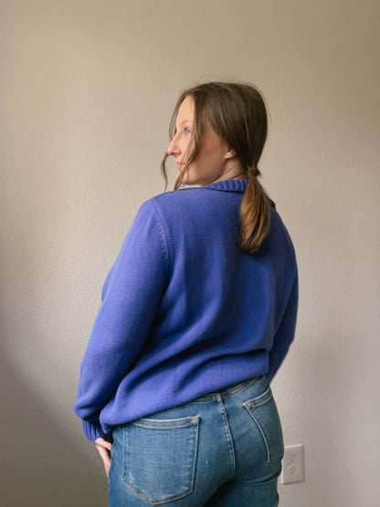 Woman wearing a blue cable knit sweater against a plain background Indigo Cable Knit Pullover | From the Rack | Grace Thrifts